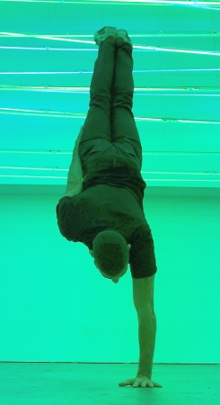 Homme habillé en vert faisant un ATR (appui tendu renversé) sur une main