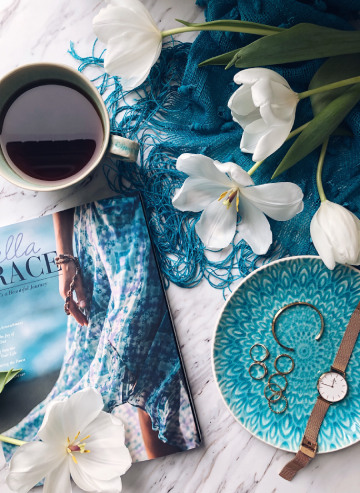 Une tasse de café, un magazine et des bijoux