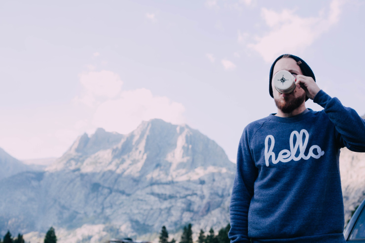 Un homme qui boit avec un pull hello