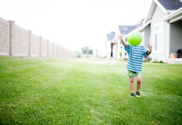 Un enfant qui joue avec un ballon vert