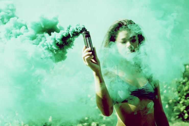 Une fille avec un fumigène vert