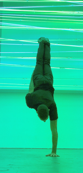 Un homme qui fait un poirier à sur une seule main