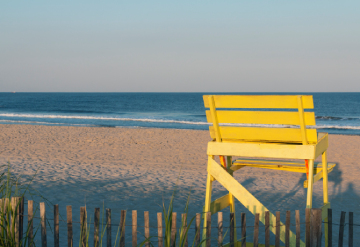 Une chaise haute jaune devant la mer