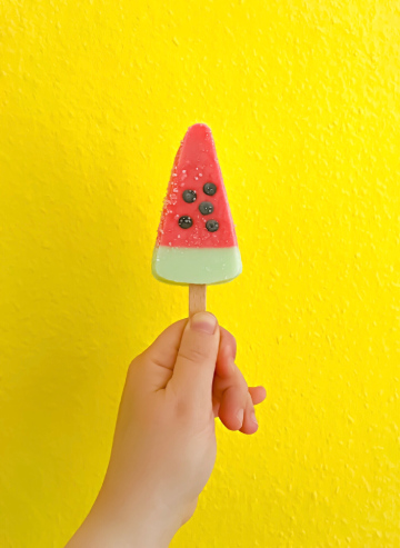 Une glasse à la pastèque devant un mur jaune
