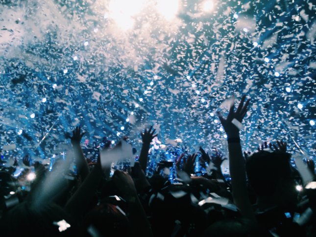 Foule en festival avec lumières bleues et confettis