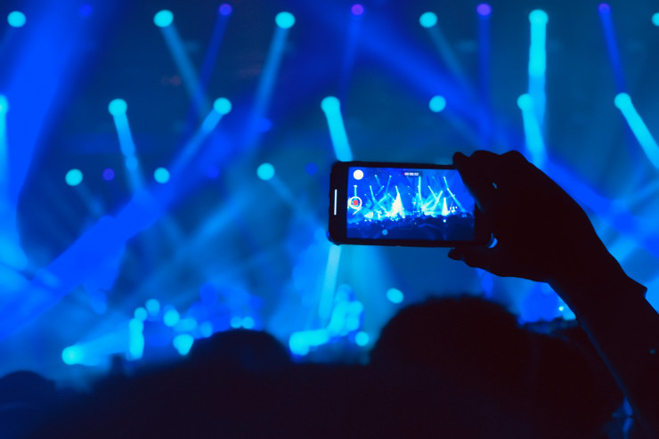 Personne filmant un concert en festival avec son smartphone