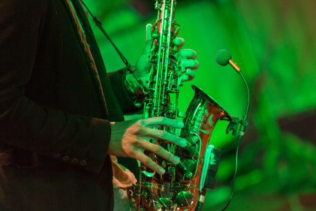 Saxophoniste sur scène avec des lumières vertes