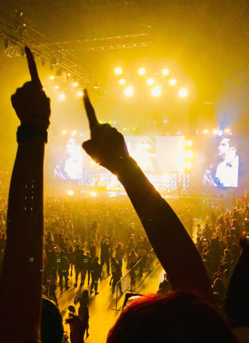 Foule devant un concert avec des lumières jaunes