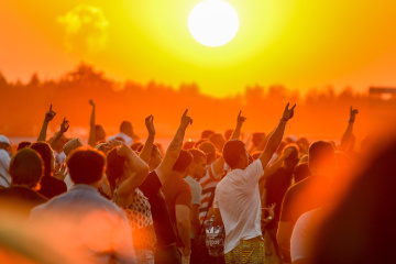 Foule en festival avec un coucher de soleil jaune orangé