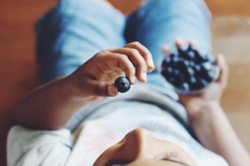 femme qui mange des myrtilles vu de haut