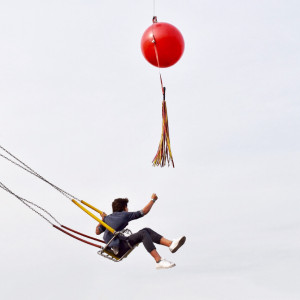 Personne sur balançoire attrapant des ballons